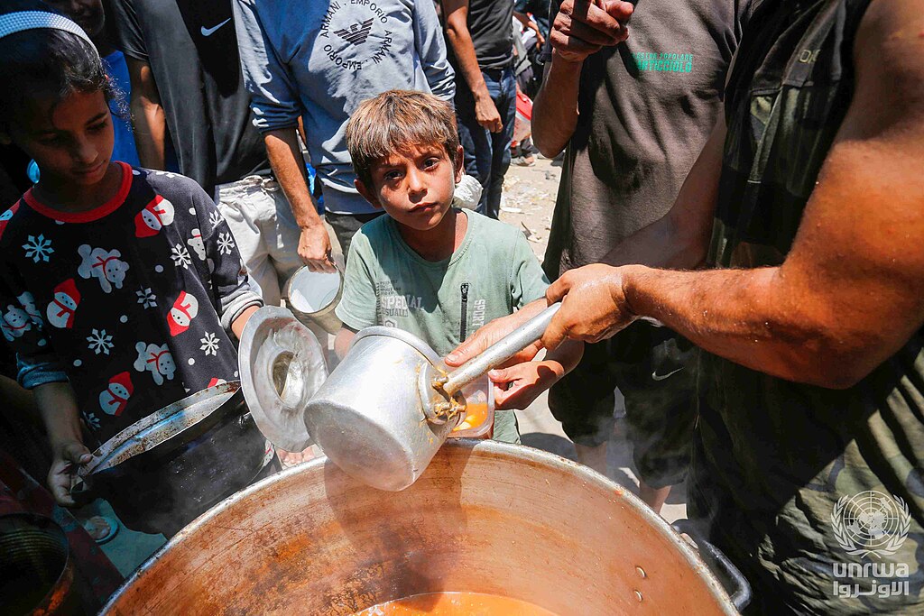 Displaced Palestinians gather to receive food from a charity in Deir el-Balah, Gaza Strip